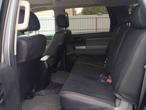 L'intérieur d'un 4x4 au Kirghizistan, montrant les sièges arrière et les tapis de sol, avec la portière arrière ouverte.