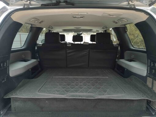L'espace de chargement spacieux d'un 4x4 au Kirghizistan, avec un tapis de sol plat en caoutchouc et les sièges arrière rabattus.