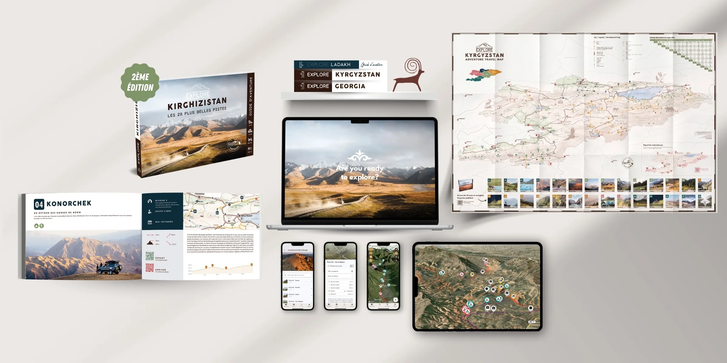 Une collection de matériel touristique pour le Kirghizstan, comprenant des cartes, des guides, un ordinateur portable, une tablette et des smartphones affichant des guides régionaux, des attractions locales et des informations de voyage détaillées sur un fond clair.