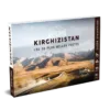 OunTravela - Page d'accueil 30 Coffret intitulé KIRGHIZISTAN : LES 28 PLUS BELLES PISTES représentant un paysage de montagnes et de plaines herbeuses, avec un cycliste sur un chemin. Le coffret est étiqueté Explore et décrit comme un guide d'aventure.