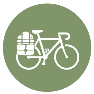 Icône représentant un vélo blanc muni de sacoches à l'arrière, sur fond circulaire vert.